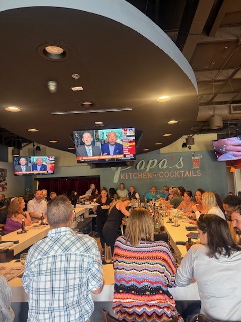 Guests gathered at the bar under the Papa's Kitchen + Cocktails sign